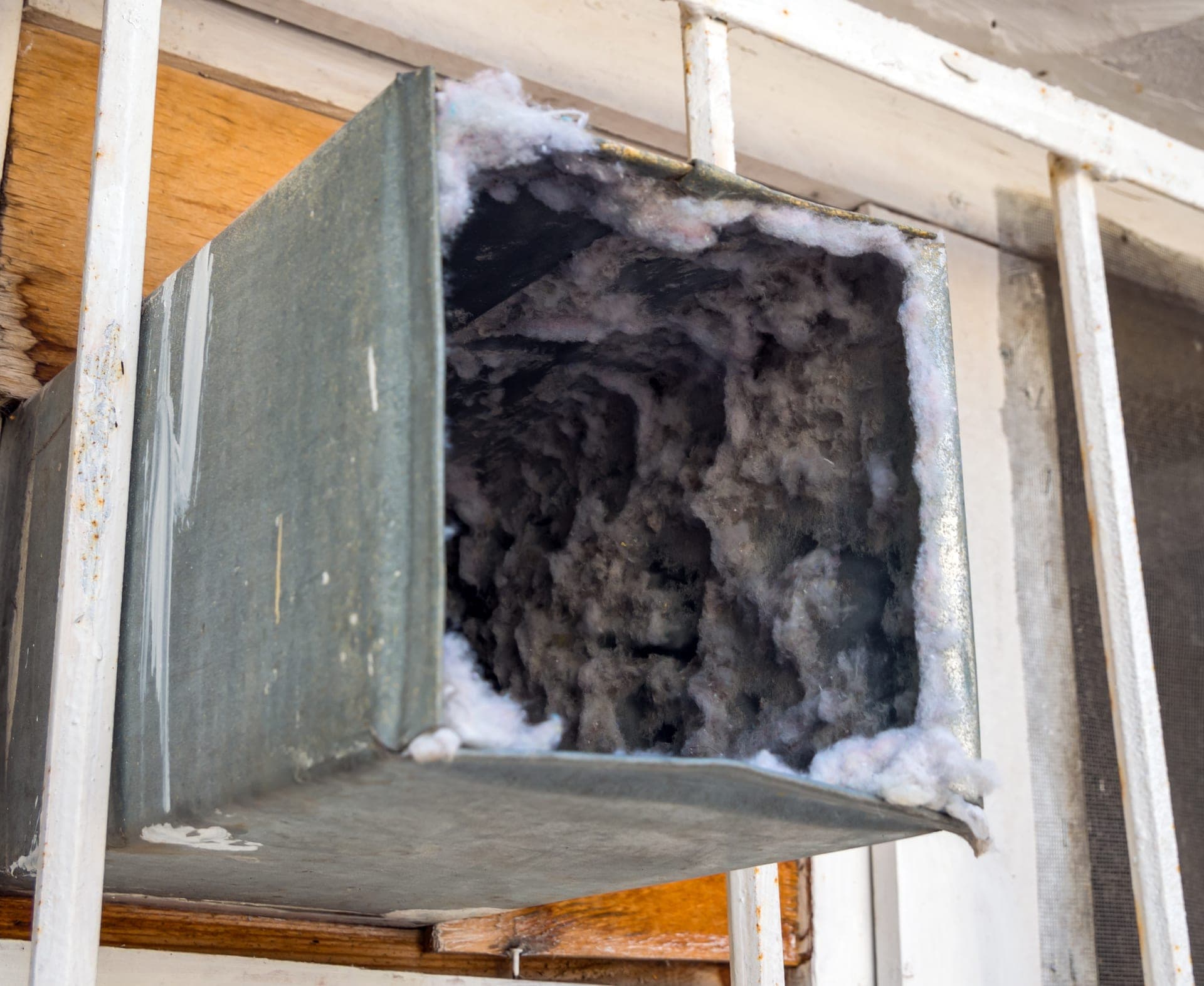 Radon mitigation PVC vent pipe and fan installation on a residential home
