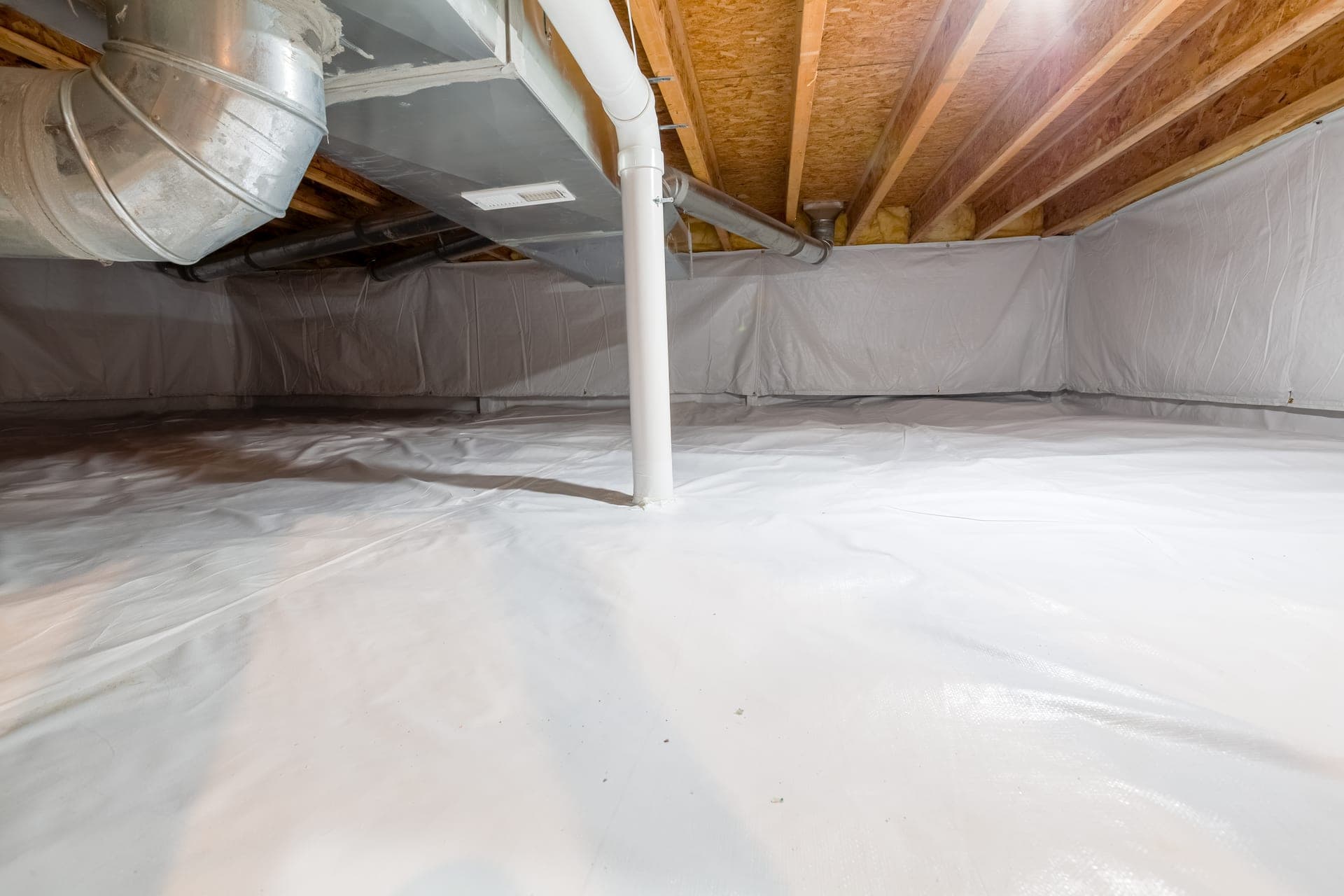 A crawl space fully lined with a white vapor barrier